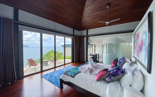 Luxury oceanfront bedroom with panoramic sea views in Kamala, featuring modern decor and direct acce.