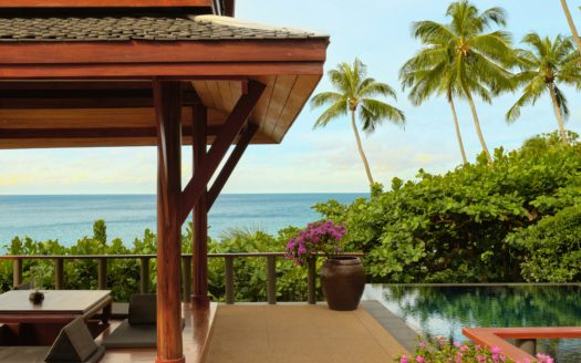 Beachside luxury villa with ocean view and tropical landscaping.