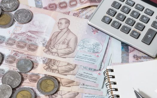 Financial planning with cash, coins, calculator, and notepad.