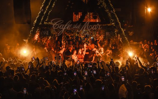 Nighttime event at Cafe del Mar with a lively crowd and stage performance.