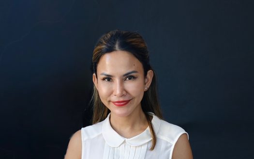 Professional woman smiling at the Anan Property Group office, showcasing confidence and expertise in.