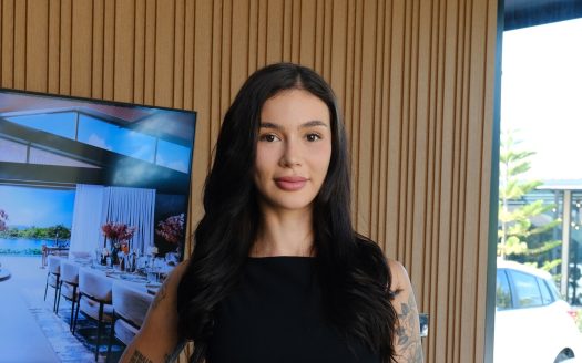 Elegant Mayumi Wada posing at Anan Property Group event in a modern office setting.