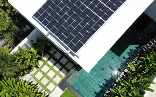 Powered home with rooftop solar panels and lush garden.
