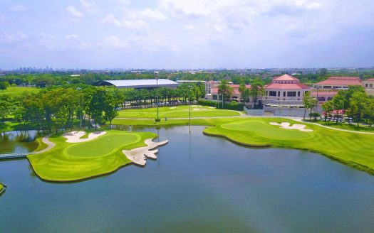 Aerial view of golf course with clubhouse and lake