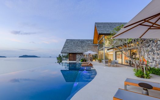 Luxury seaside villa with infinity pool at dusk
