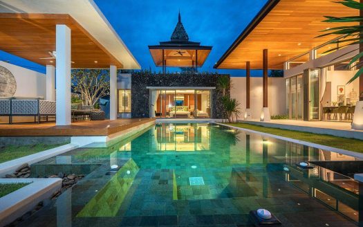 Modern luxury villa with illuminated swimming pool at dusk