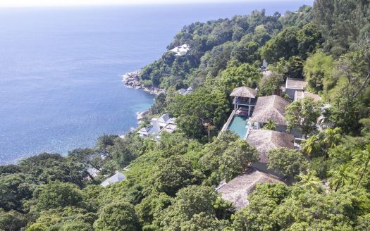 Tropical hillside villas overlooking blue ocean coastline