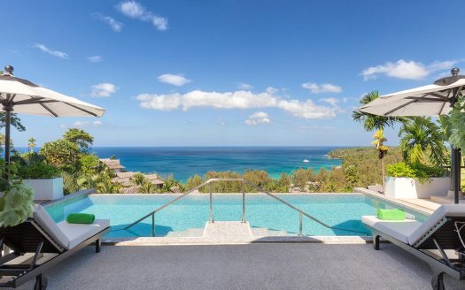 Infinity pool overlooking tropical ocean and coastline