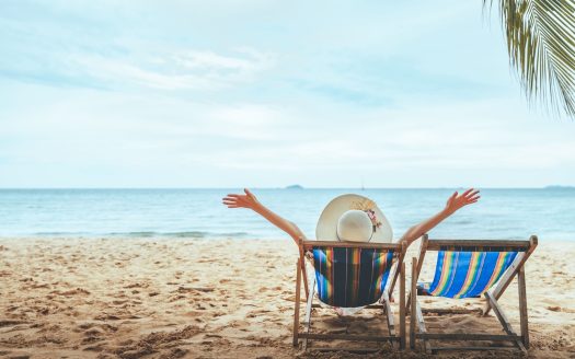 Person relaxing in deckchair on sunny beach