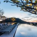 Rooftop infinity pool overlooking hills at sunset