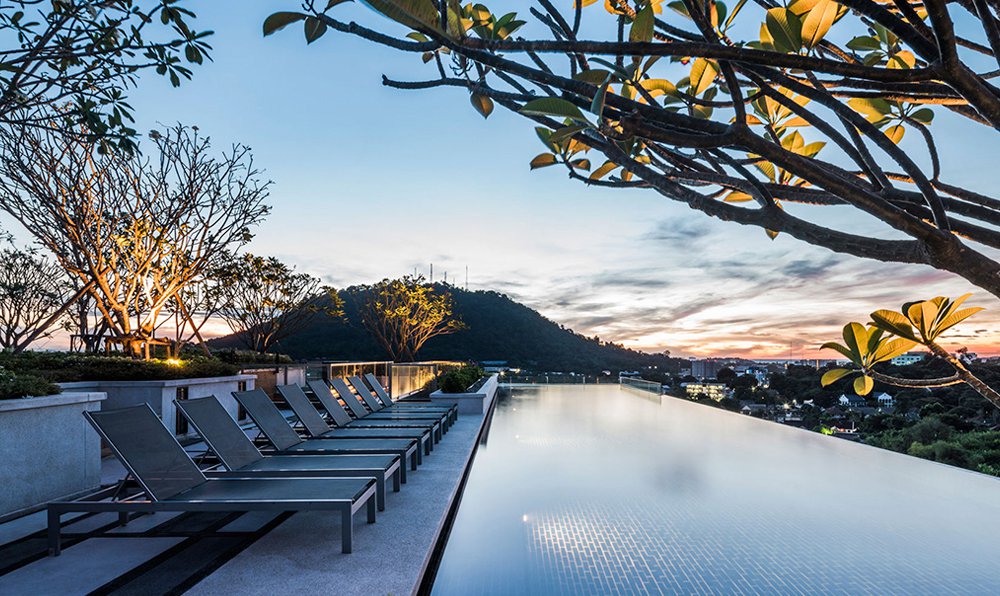 Rooftop infinity pool overlooking hills at sunset