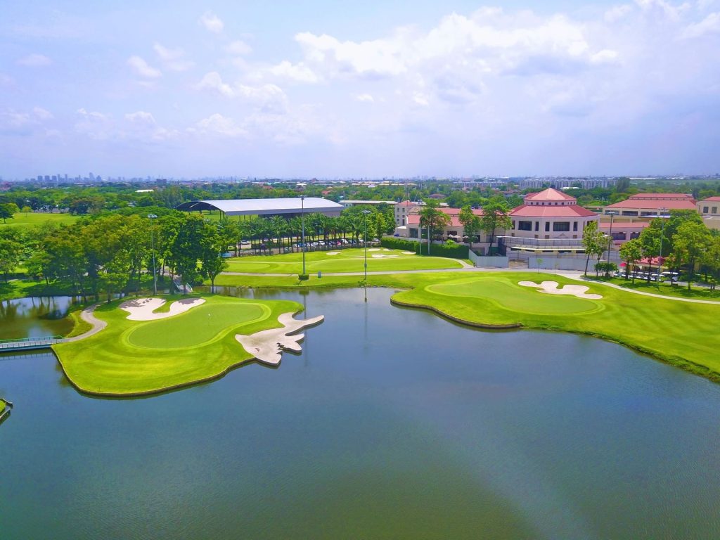 Aerial view of golf course with clubhouse and lake