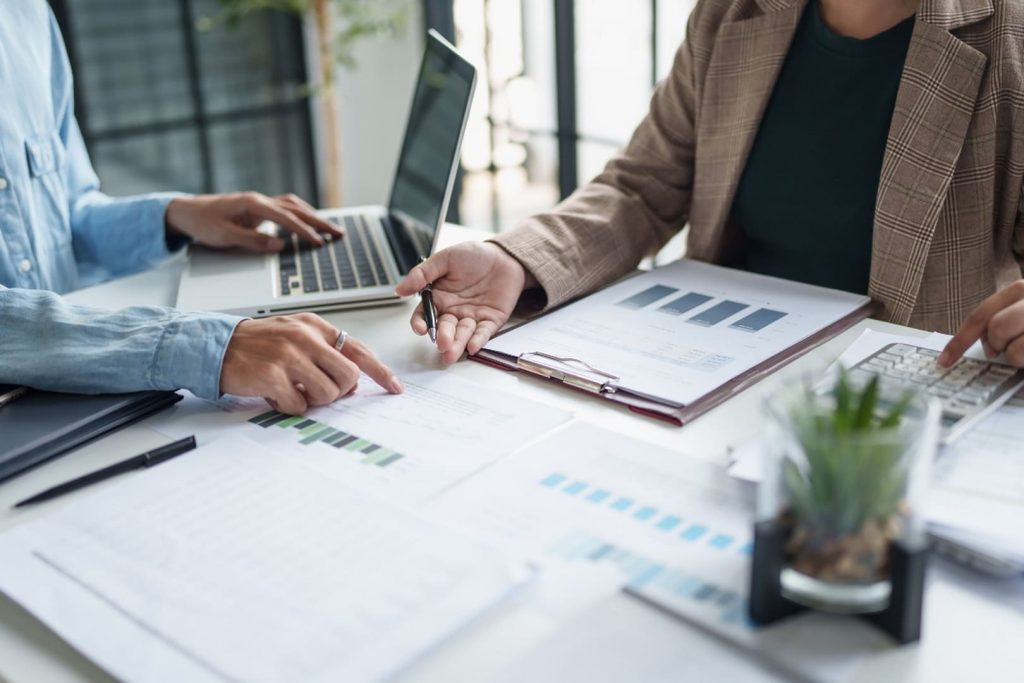 Colleagues reviewing financial charts at office desk