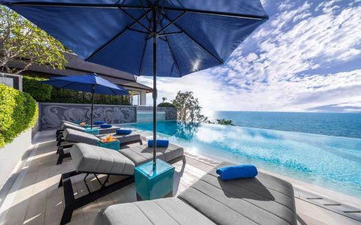 Luxury infinity pool overlooking ocean with sun loungers