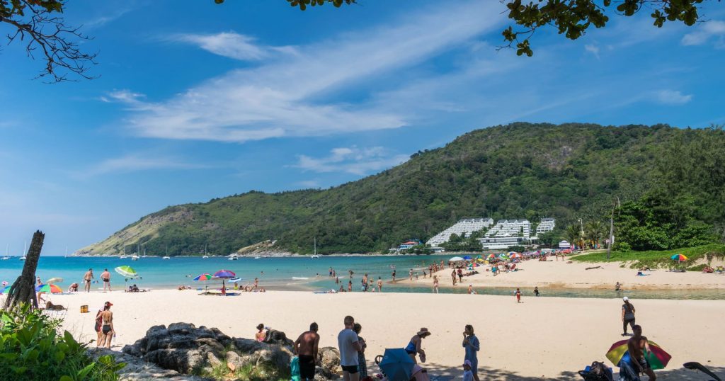 Sunny beach with turquoise sea and hillside resort
