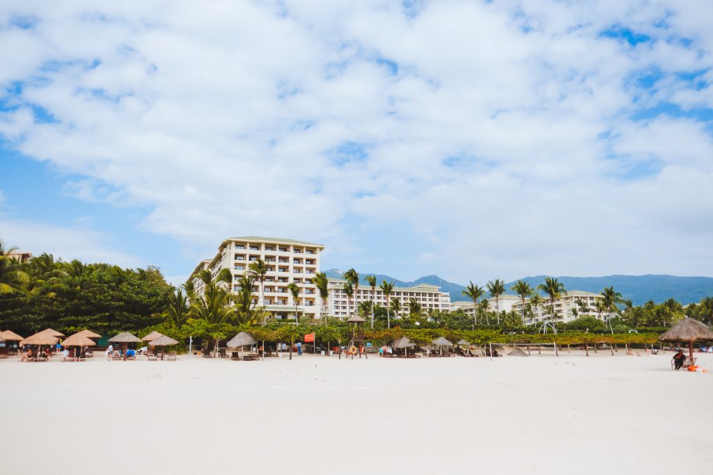 Beachfront resort with palm trees and mountains